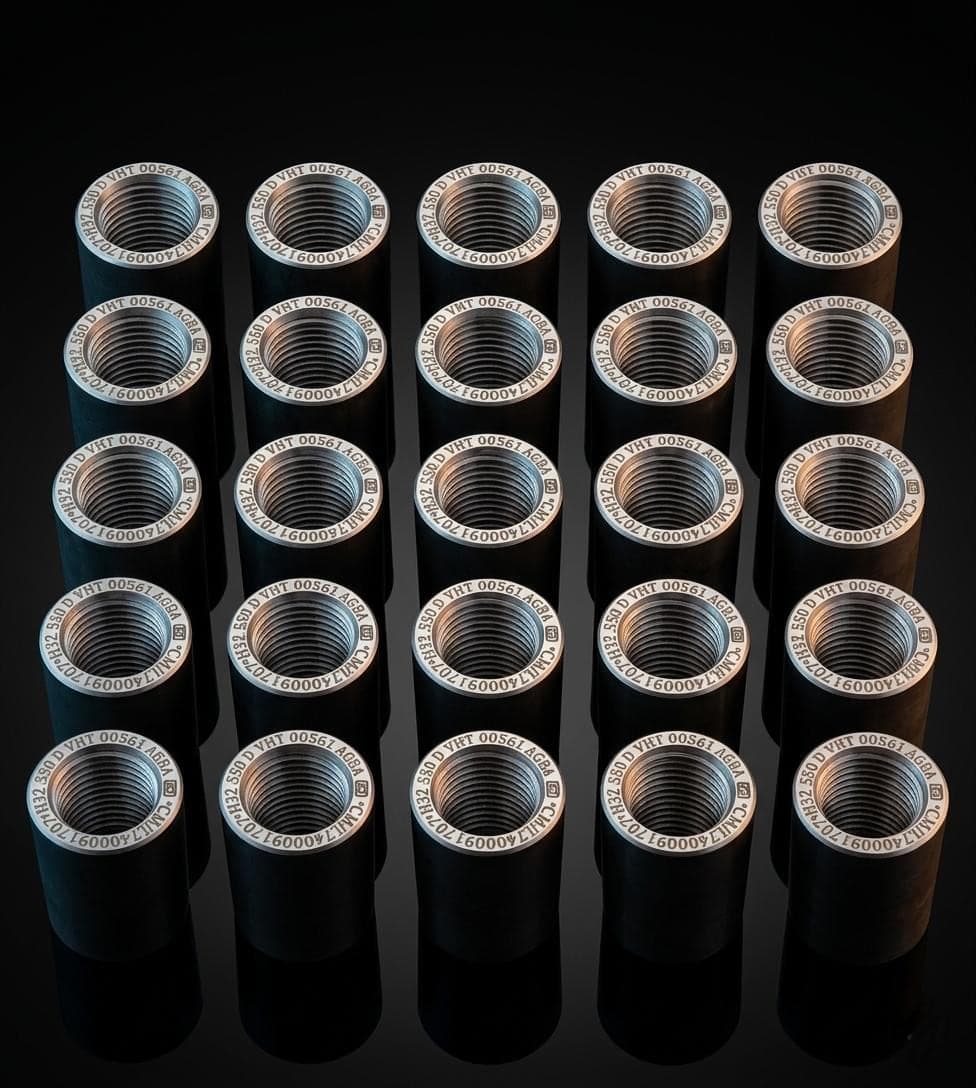 Twenty-five finished AGBA couplers stood on end in rows, each ring laser-marked with the same batch number, class and BIS licence.